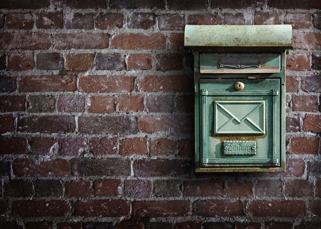 a green mail box on a brick wall - Download Free Stock Photos Pikwizard.com