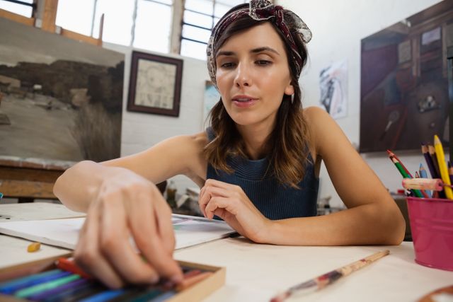 Attentive woman drawing on book in drawing class