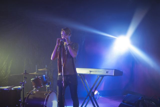 Confident male singer performing on illuminated stage in nightclub