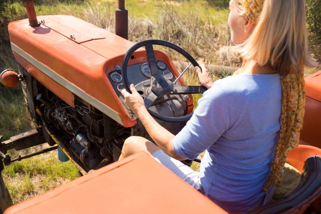 Rear view of woman driving tractor in olive farm - Download Free Stock Photos Pikwizard.com