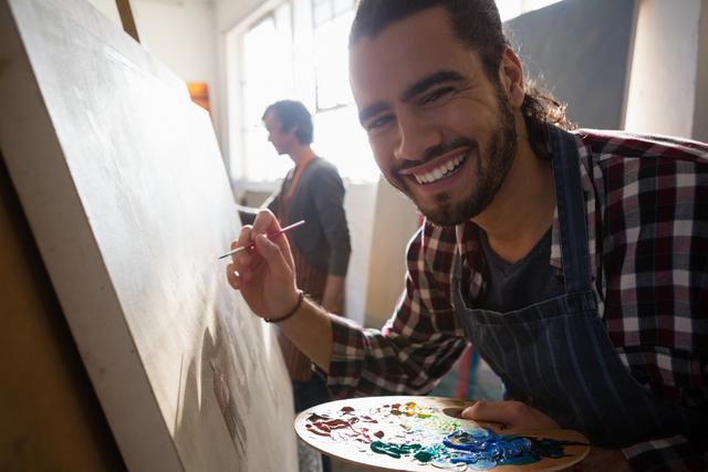 Close up portrait of smiling man painting on artists canvas - Download Free Stock Photos Pikwizard.com