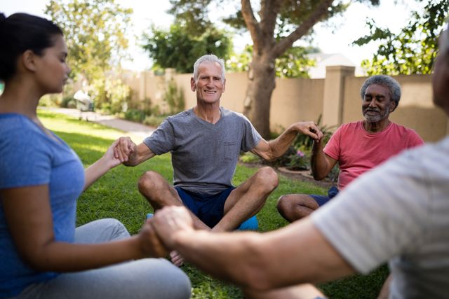 Smiling senior people meditating with young trainer - Download Free Stock Photos Pikwizard.com
