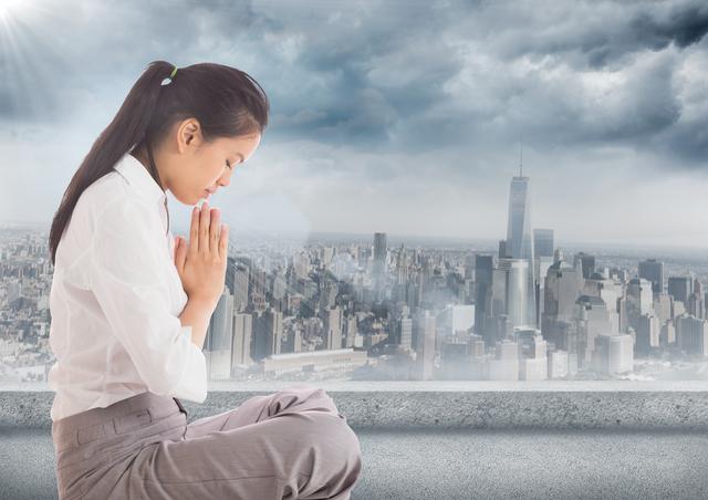 Business woman with flare praying against grey skyline and clouds - Download Free Stock Photos Pikwizard.com