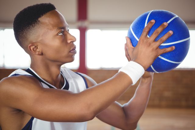 Close up of teenager practicing basketball in court