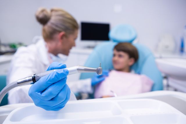 Close up of dentist holding medical equipment while examining boy - Download Free Stock Photos Pikwizard.com