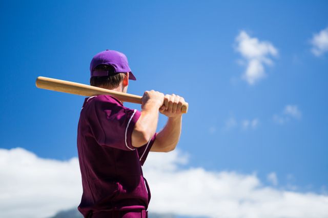 Low angle side view of baseball player holding bat against blue sky - Download Free Stock Photos Pikwizard.com
