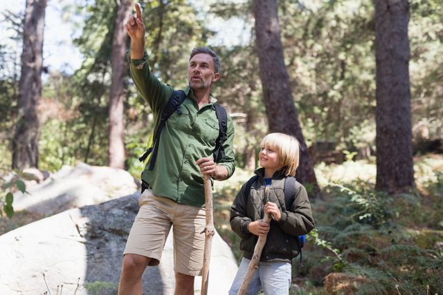 Father pointing away with son in forest - Download Free Stock Photos Pikwizard.com