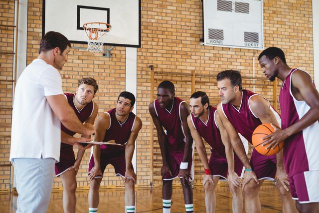 Coach explaining game plan to basketball players in the court