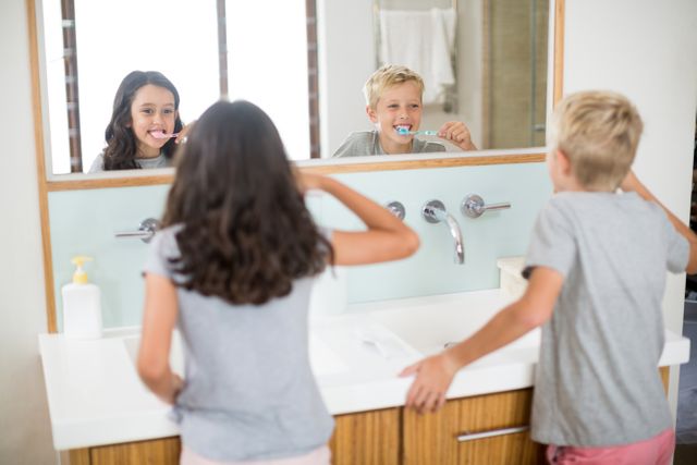 Siblings brushing their teeth in bathroom - Download Free Stock Photos Pikwizard.com