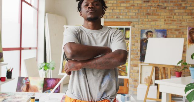 Portrait of african american male artist with arms crossed at art studio. art, hobby and creative occupation concept