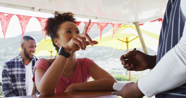 African american woman ordering food at the food truck. food truck and street food concept