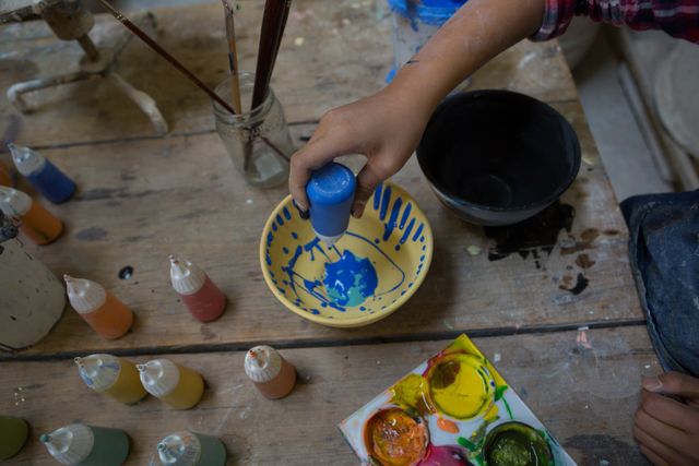 Girl decorating bowl with paint - Download Free Stock Photos Pikwizard.com