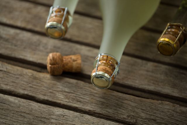 Bottles of champagne and its cork on wooden surface - Download Free Stock Photos Pikwizard.com