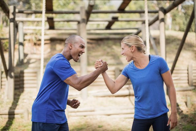 Fit man and woman greeting each other during obstacle course - Download Free Stock Photos Pikwizard.com