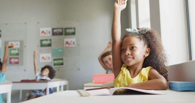 Image of happy african american girl raising hand during lesson. primary school education and learning concept.