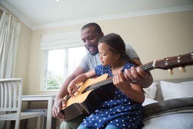 Father teaching his daughter to play the guitar - Download Free Stock Photos Pikwizard.com