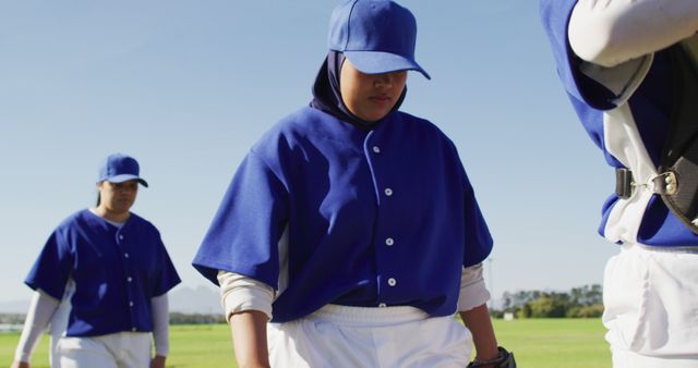 Disappointed diverse female baseball players, walking off the field after losing a game. sports training and game tactics.
