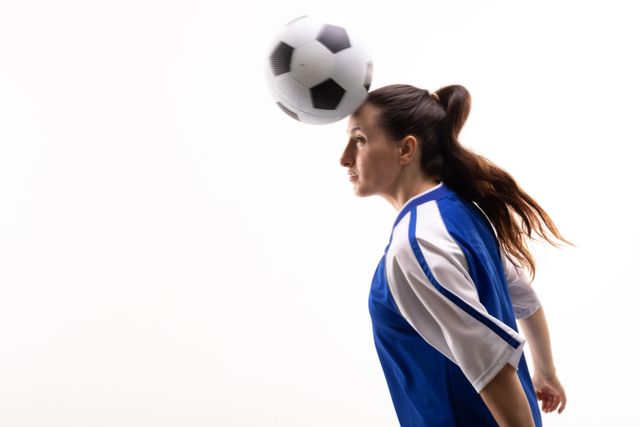 Side view of female caucasian athlete heading soccer ball by copy space on white background - Download Free Stock Photos Pikwizard.com