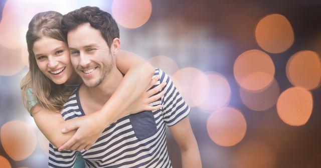 Happy woman hugging man from behind over bokeh - Download Free Stock Photos Pikwizard.com