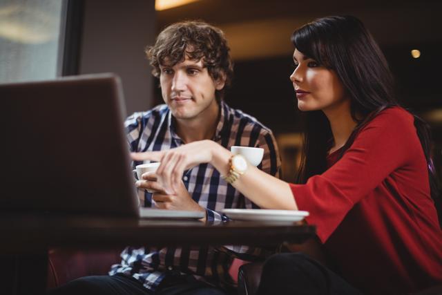Couple using laptop while having coffee - Download Free Stock Photos Pikwizard.com
