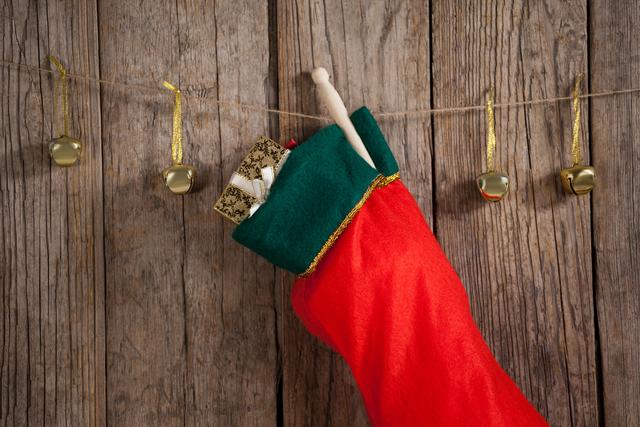 Christmas stocking and bells hanging against wooden wall - Download Free Stock Photos Pikwizard.com