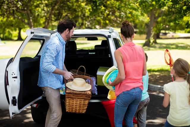 Family placing picnic items in car trunk - Download Free Stock Photos Pikwizard.com