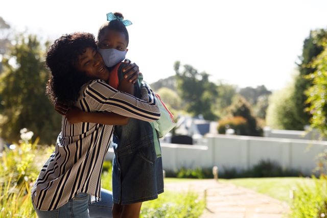 Close up of an african-american mother hugging with her daughter on the front porch - Download Free Stock Photos Pikwizard.com