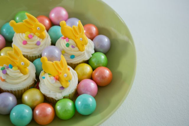 Colorful chocolate Easter eggs with cup cakes in bowl - Download Free Stock Photos Pikwizard.com