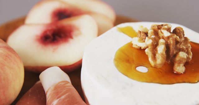 A gourmet plate with cheese, walnuts, honey, and peach slices offers a sensory feast. - Download Free Stock Photos Pikwizard.com