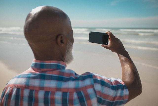African american senior male standing on beach using smartphone with copy space - Download Free Stock Photos Pikwizard.com