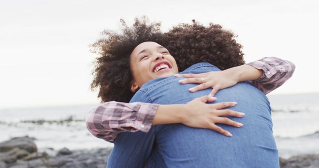 African american woman hugging her husband on the rocks near the sea - Download Free Stock Photos Pikwizard.com