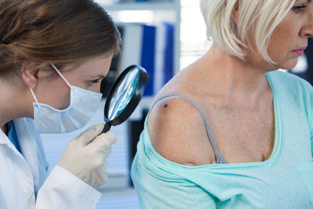 Dermatologist examining mole of female patient with magnifying glass - Download Free Stock Photos Pikwizard.com