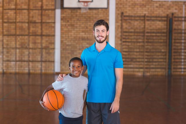 Portrait of sports teacher standing with his student in basketball court - Download Free Stock Photos Pikwizard.com