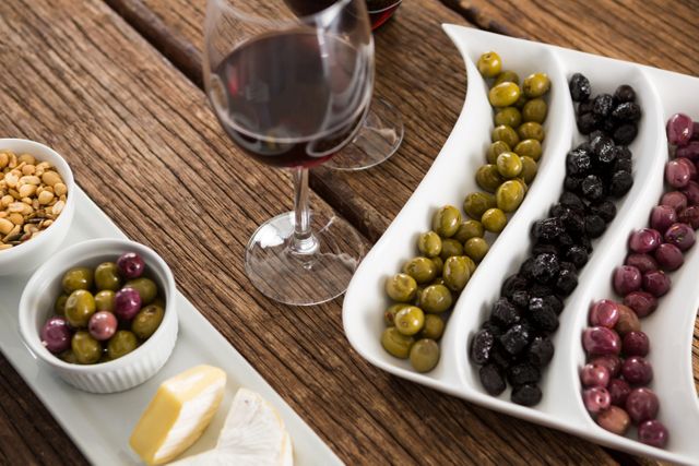 Close-up of marinated olives with glasses of wine - Download Free Stock Photos Pikwizard.com