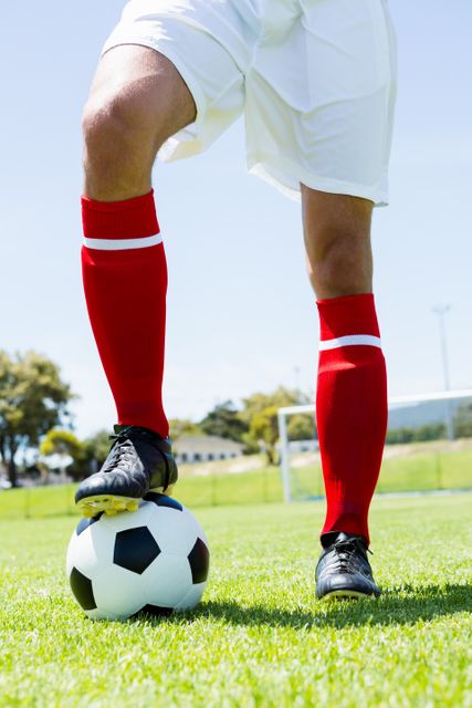 Football player standing with his feet on ball - Download Free Stock Photos Pikwizard.com