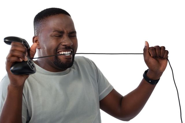 Frustrated man biting a wire of joystick - Download Free Stock Photos Pikwizard.com