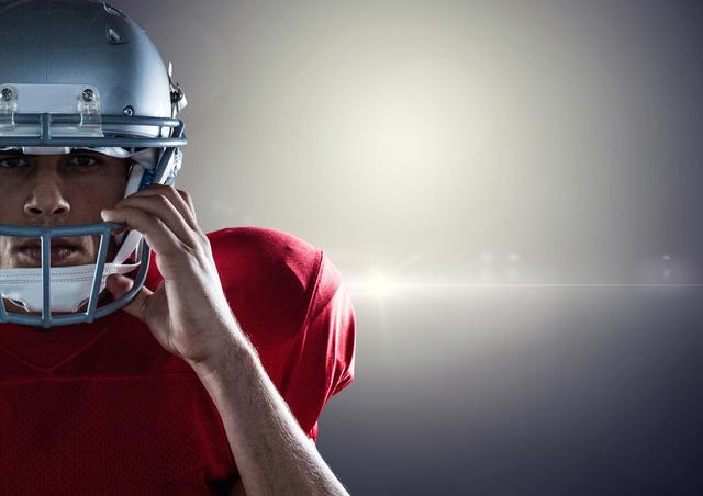 American football player holding helmet against grey background - Download Free Stock Photos Pikwizard.com