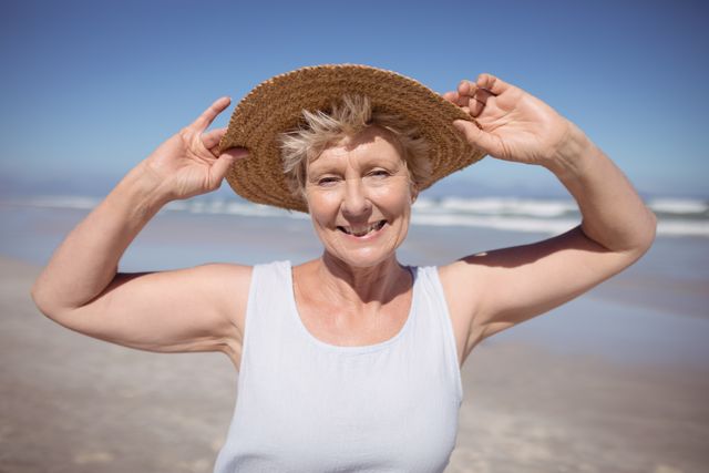 Portrait of senior woman wearing sun hat at beach - Download Free Stock Photos Pikwizard.com