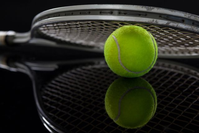 Close up of racket on fluorescent yellow tennis ball with reflection - Download Free Stock Photos Pikwizard.com