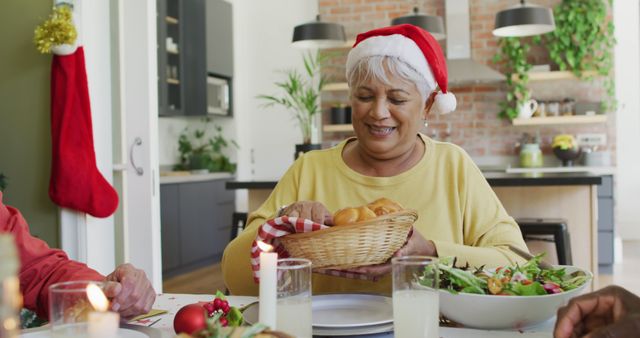 Group of happy diverse senior friends in santa hats passing food at christmas dinner table at home. retirement lifestyle, christmas festivities, celebrating at home with friends.