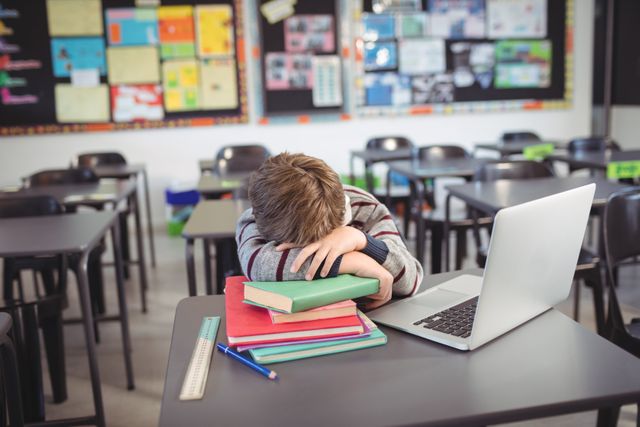 Tired schoolboy sleeping on stack of in classroom - Download Free Stock Photos Pikwizard.com