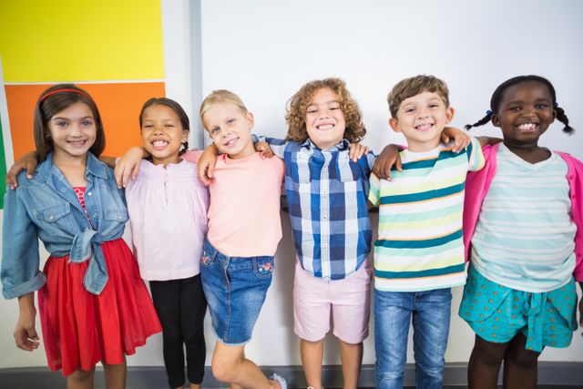 Smiling kids standing with arm around in classroom - Download Free Stock Photos Pikwizard.com