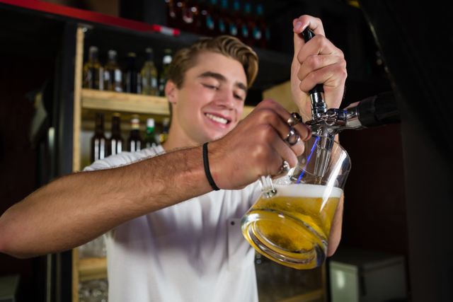 Happy bartender preparing beer - Download Free Stock Photos Pikwizard.com