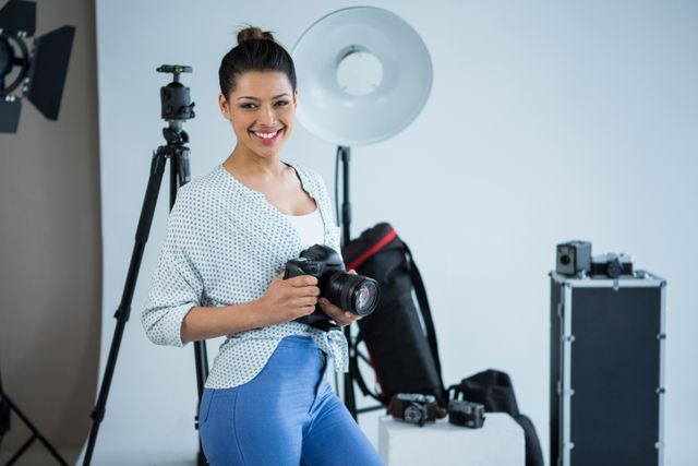 Happy female photographer standing in studio - Download Free Stock Photos Pikwizard.com