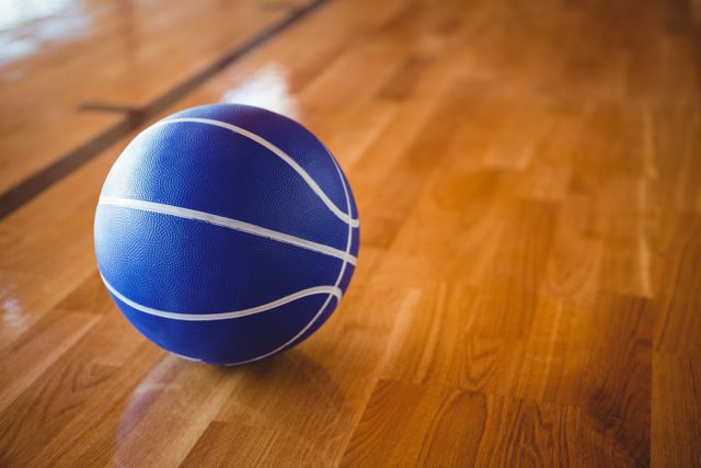 Close up of blue basketball on hardwood floor  - Download Free Stock Photos Pikwizard.com