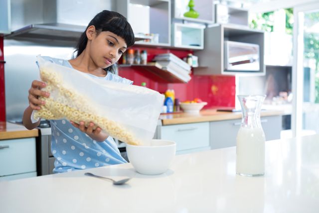 Girl pouring breakfast cereal in bowl - Download Free Stock Photos Pikwizard.com
