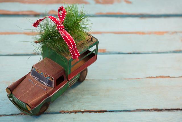 Toy tempo carrying christmas fir on wooden plank - Download Free Stock Photos Pikwizard.com