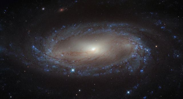 Lying more than 110 million light-years away from Earth in the constellation of Antlia (The Air Pump) is the spiral galaxy IC 2560, shown here in an image from NASA/ESA Hubble Space Telescope. At this distance it is a relatively nearby spiral galaxy, and is part of the Antlia cluster — a group of over 200 galaxies held together by gravity. This cluster is unusual; unlike most other galaxy clusters, it appears to have no dominant galaxy within it. In this image, it is easy to spot IC 2560's spiral arms and barred structure. This spiral is what astronomers call a Seyfert-2 galaxy, a kind of spiral galaxy characterized by an extremely bright nucleus and very strong emission lines from certain elements — hydrogen, helium, nitrogen, and oxygen. The bright center of the galaxy is thought to be caused by the ejection of huge amounts of super-hot gas from the region around a central black hole. There is a story behind the naming of this quirky constellation — Antlia was originally named antlia pneumatica by French astronomer Abbé Nicolas Louis de Lacaille, in honor of the invention of the air pump in the 17th century.  Credit: Hubble/European Space Agency and NASA  <b><a href="http://www.nasa.gov/audience/formedia/features/MP_Photo_Guidelines.html" rel="nofollow">NASA image use policy.</a></b>  <b><a href="http://www.nasa.gov/centers/goddard/home/index.html" rel="nofollow">NASA Goddard Space Flight Center</a></b> enables NASA’s mission through four scientific endeavors: Earth Science, Heliophysics, Solar System Exploration, and Astrophysics. Goddard plays a leading role in NASA’s accomplishments by contributing compelling scientific knowledge to advance the Agency’s mission.  <b>Follow us on <a href="http://twitter.com/NASA_GoddardPix" rel="nofollow">Twitter</a></b>  <b>Like us on <a href="http://www.facebook.com/pages/Greenbelt-MD/NASA-Goddard/395013845897?ref=tsd" rel="nofollow">Facebook</a></b>  <b>Find us on <a href="http://instagram.com/nasagoddard?vm=grid" rel="nofollow">Instagram</a></b>