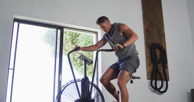 Fit sweaty caucasian man exercising on training bike inside gym - Download Free Stock Photos Pikwizard.com