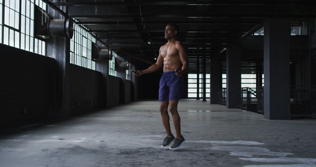 Shirtless african american man skipping the rope in an empty urban building - Download Free Stock Photos Pikwizard.com